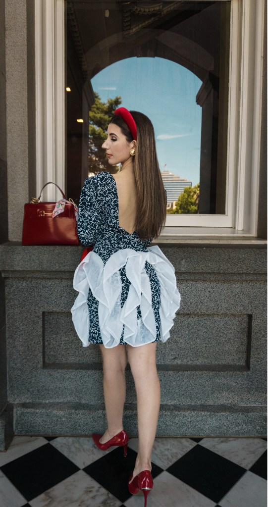 This red, blue and white dress was my mom's prom dress in the late 80s. She designed it and my grandma custom made it for her, with puffy sleeves, a big bow, and three-dimensional chiffon adornments. I wore it with a puffy headband, some red pumps, and an architectural red bag. I'm wearing it in front of the California State Capitol in Sacramento.